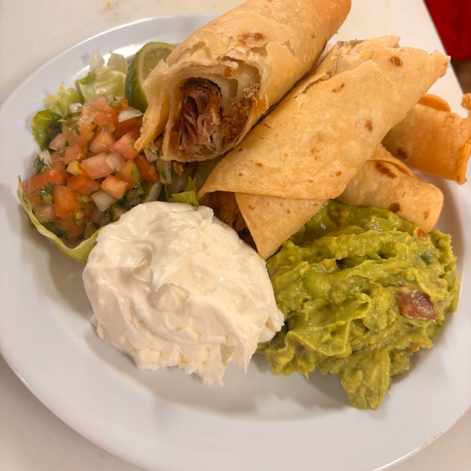 Crispy taquitos with shredded meat, served with guacamole, sour cream, pico de gallo, and lettuce.